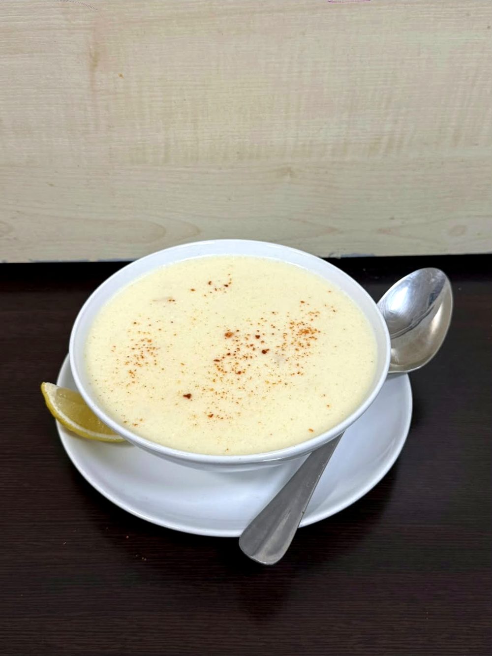 Beyaz kasede pul biberli, limonlu kremalı açık renkli çorba